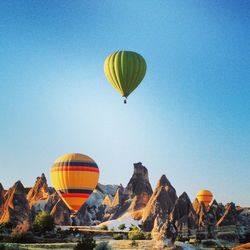 Low angle view of hot air balloons against clear blue sky