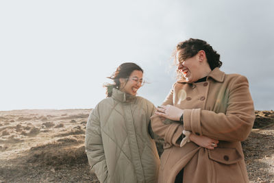 Cheerful females standing on field