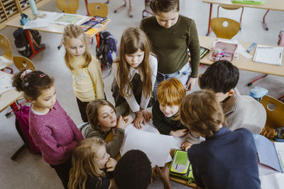 High angle view of male and female students studying together in classroom