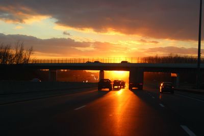 Cars moving on bridge at sunset