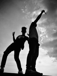 Low angle view of men standing against sky