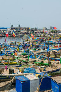 Boats moored at harbor against clear sky