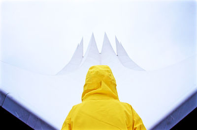 Low angle view of man sculpture against white sky