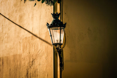 Low angle view of street light against wall