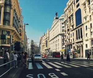 People on street in city against clear sky