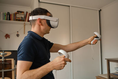 Young man in casual clothes plays virtual games at home. man in virtual reality vr helmet 