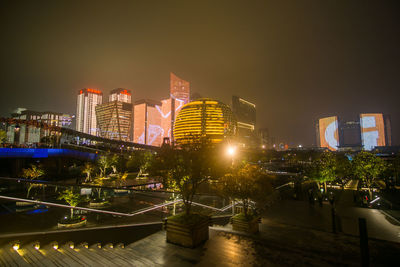 Illuminated buildings in city against sky at night