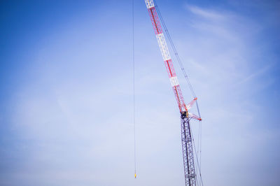 Low angle view of crane against sky