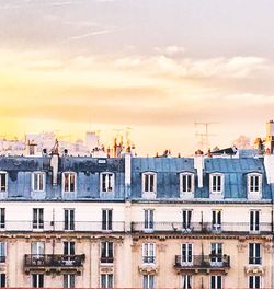 Residential buildings against sky during sunset