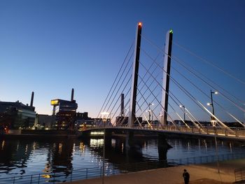 Bridge over river against clear blue sky