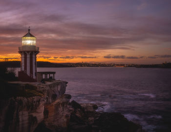 Scenic view of sea by buildings against sky during sunset