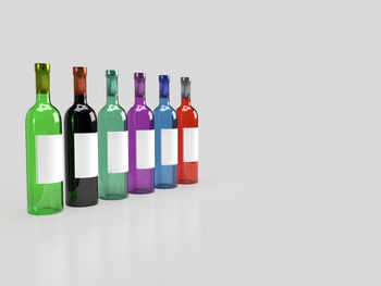 Multi colored bottles against white background