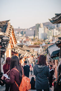 Rear view of woman standing in city against clear sky