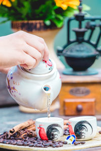 Cropped hand of person holding coffee on table