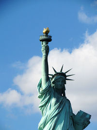 Low angle view of statue of liberty against cloudy sky