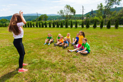 Rear view of women sitting on grassy field