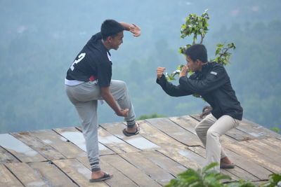 Full length of a friends enjoying on wood