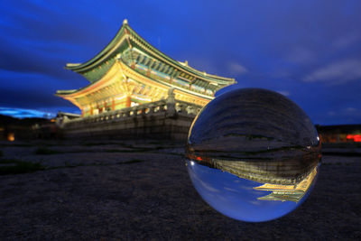 Reflection of illuminated building in blue sky at dusk