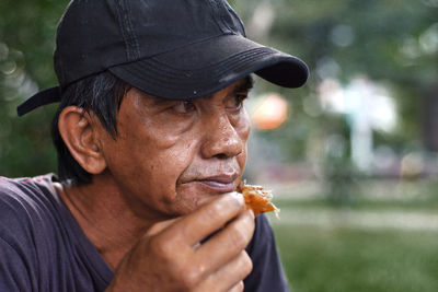 Close-up of thoughtful mature man eating food