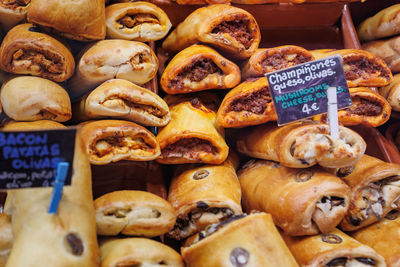 Group of stuffed sandwiches with olives, eggplant and other vegetables on the counter for sale.