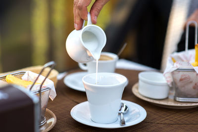 Midsection of person preparing coffee on table 