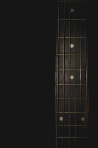 Close-up of guitar against black background