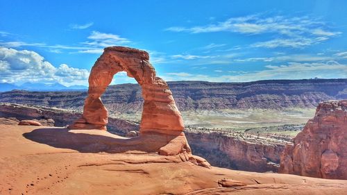 Rock formations on landscape against cloudy sky