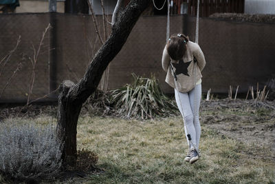 Full length of girl standing on swing