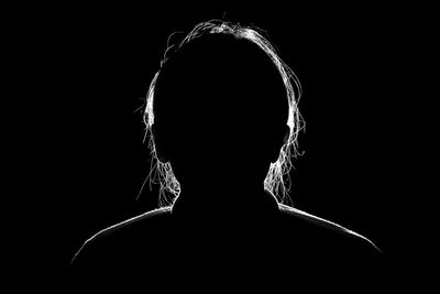 Rear view of silhouette person against black background