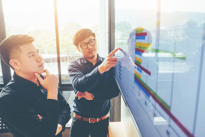 Businessman showing graph to colleague in office