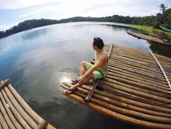 High angle view of man sitting on wooden raft 