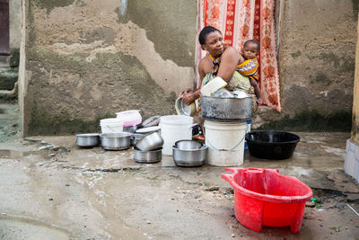 Woman with children washing utensils at home