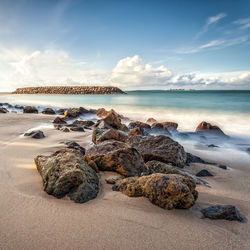 Rocks on beach against sky