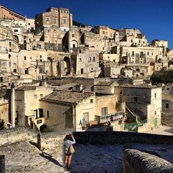 Woman photographing townscape against sky