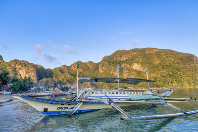 Boats moored in lake against sky