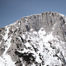 Low angle view of snowcapped mountains against clear sky