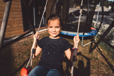 Boy sitting on swing at playground