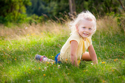 Portrait of cute girl lying on grassy field