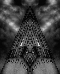 Low angle view of modern building against cloudy sky