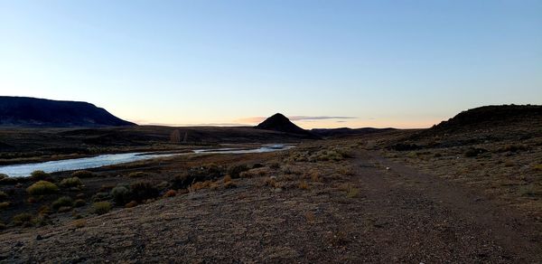 Scenic view of landscape against clear sky during sunset