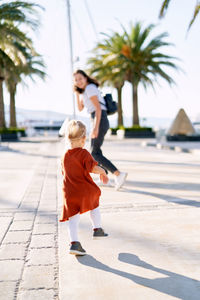 Rear view of woman with umbrella on footpath