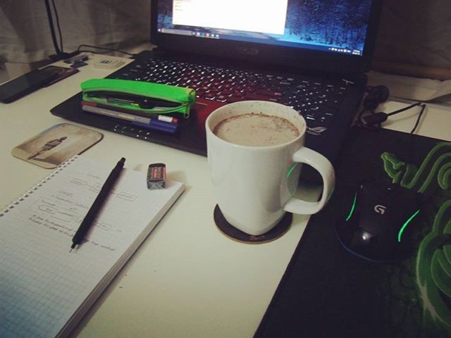 indoors, table, coffee cup, still life, drink, high angle view, food and drink, coffee - drink, laptop, book, refreshment, cup, communication, coffee, close-up, wireless technology, no people, pen, technology, freshness