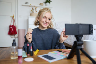 Portrait of young woman sitting on table