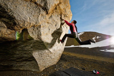 Woman bouldering on rock in rural iceland