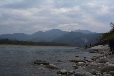 Scenic view of sea and mountains against sky