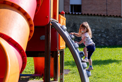 Rear view of girl playing in playground