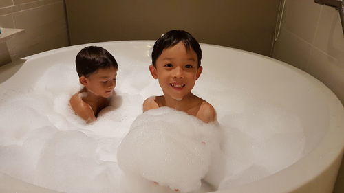 High angle view of brothers bathing in bathtub