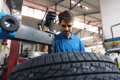 Low angle view of mechanic repairing car