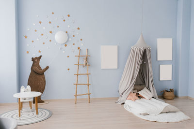 The interior of the children's room is decorated in blue and beige colors. the bear holds 