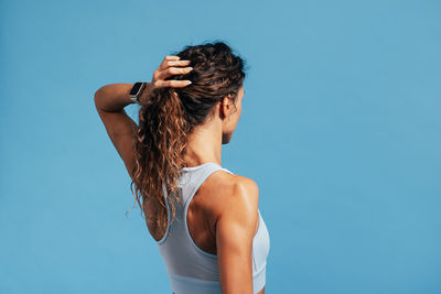 Rear view of athlete against blue background